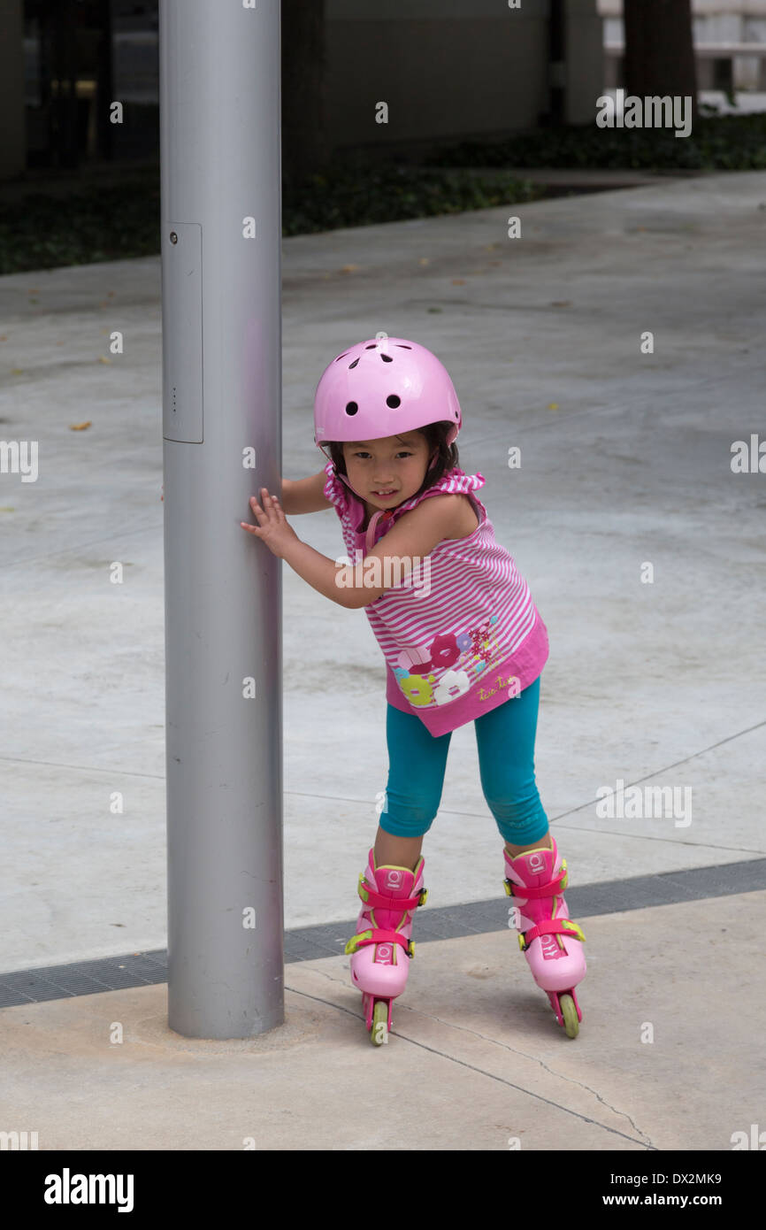 Giovane carina ragazza asiatica sul rullo lame, Roma, Italia Foto Stock