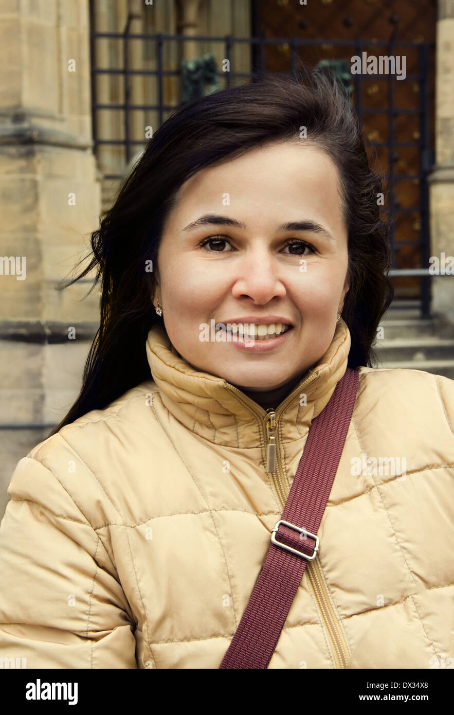 Piuttosto giovani brunette con sorriso affascinante sulla città vecchia sullo sfondo Foto Stock
