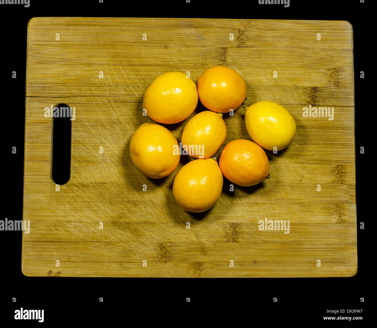 Sette i limoni Meyer su un tagliere in attesa di essere affettato. Foto Stock