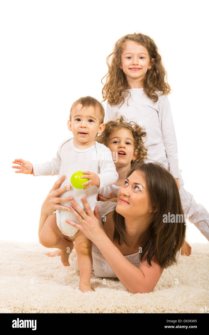 Allegro famiglia della madre e tre bambini giacente su un tappeto home Foto Stock