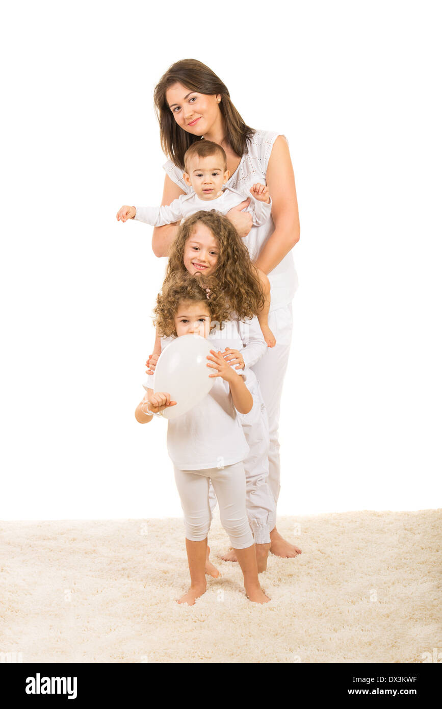 Bella famiglia in bianche vesti in piedi in una fila su un tappeto isolato su sfondo bianco Foto Stock