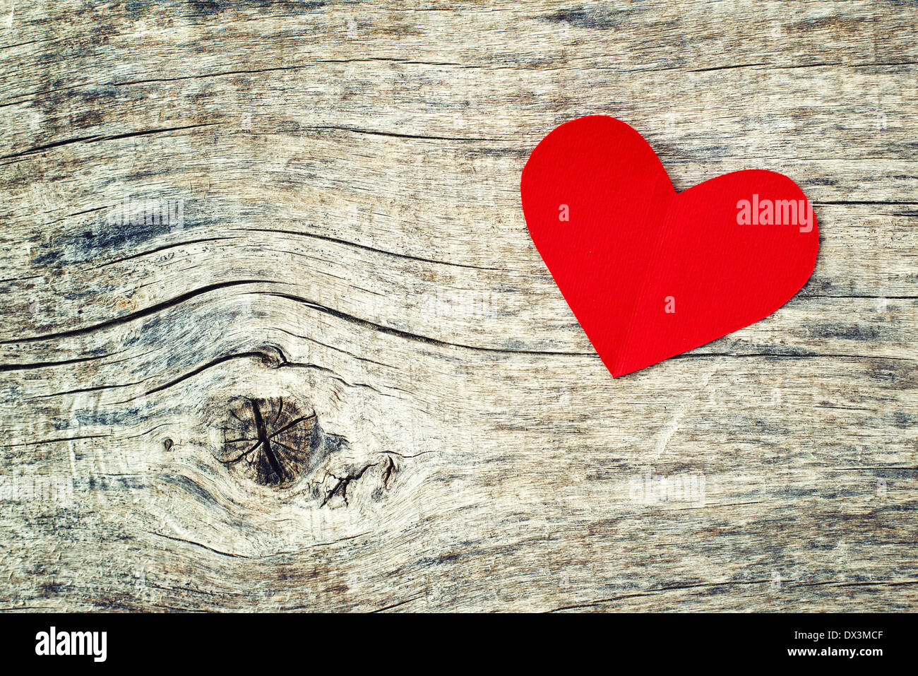 Carta rossa cuore su grunge sfondo di legno con una copia dello spazio per il tuo San Valentino messaggio Foto Stock