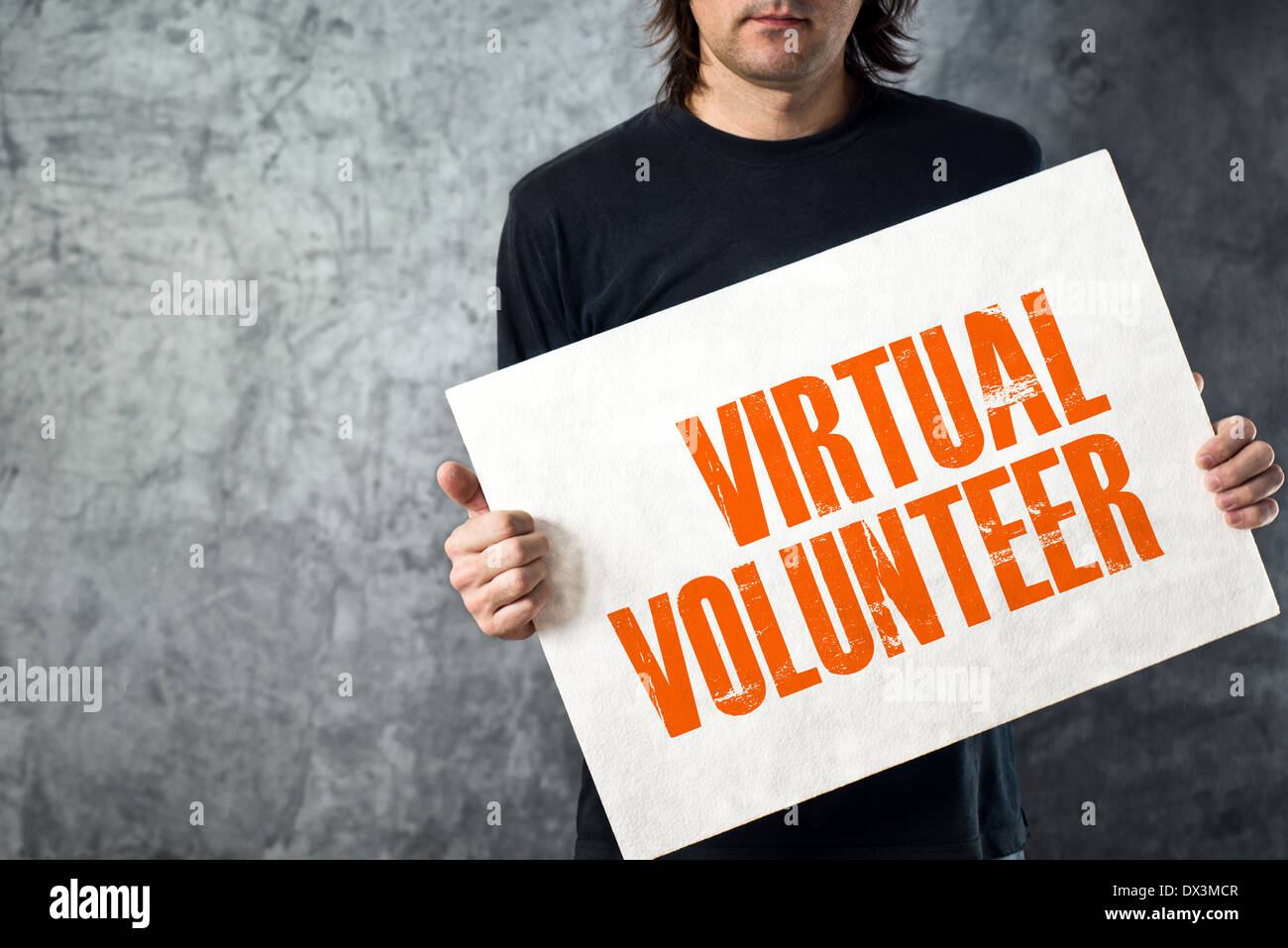 Uomo con banner bianco virtuali con il titolo di volontariato, immagine concettuale Foto Stock