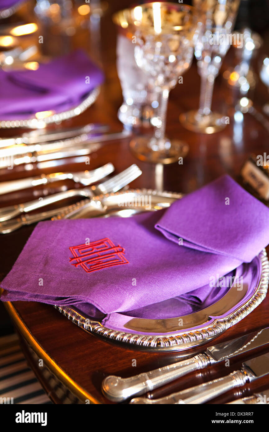 Viola ricamato tovaglioli formale sul tavolo da pranzo con le regolazioni del posto, ad alto angolo di visione Foto Stock