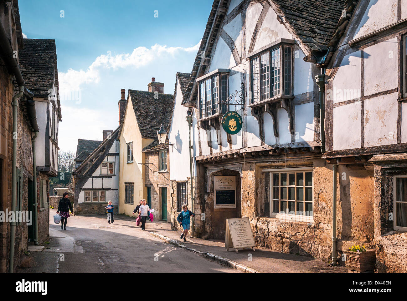 Lacock village con la scuola i bambini tornando a casa da scuola nel pomeriggio Foto Stock