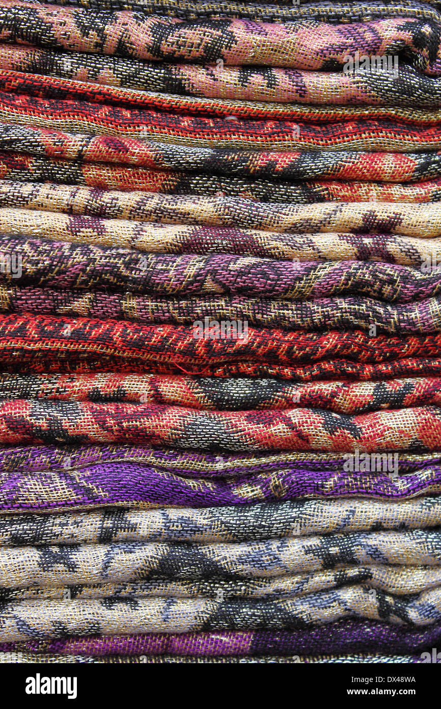 Pila di sciarpe pashmina per la vendita in un negozio di moda Foto Stock