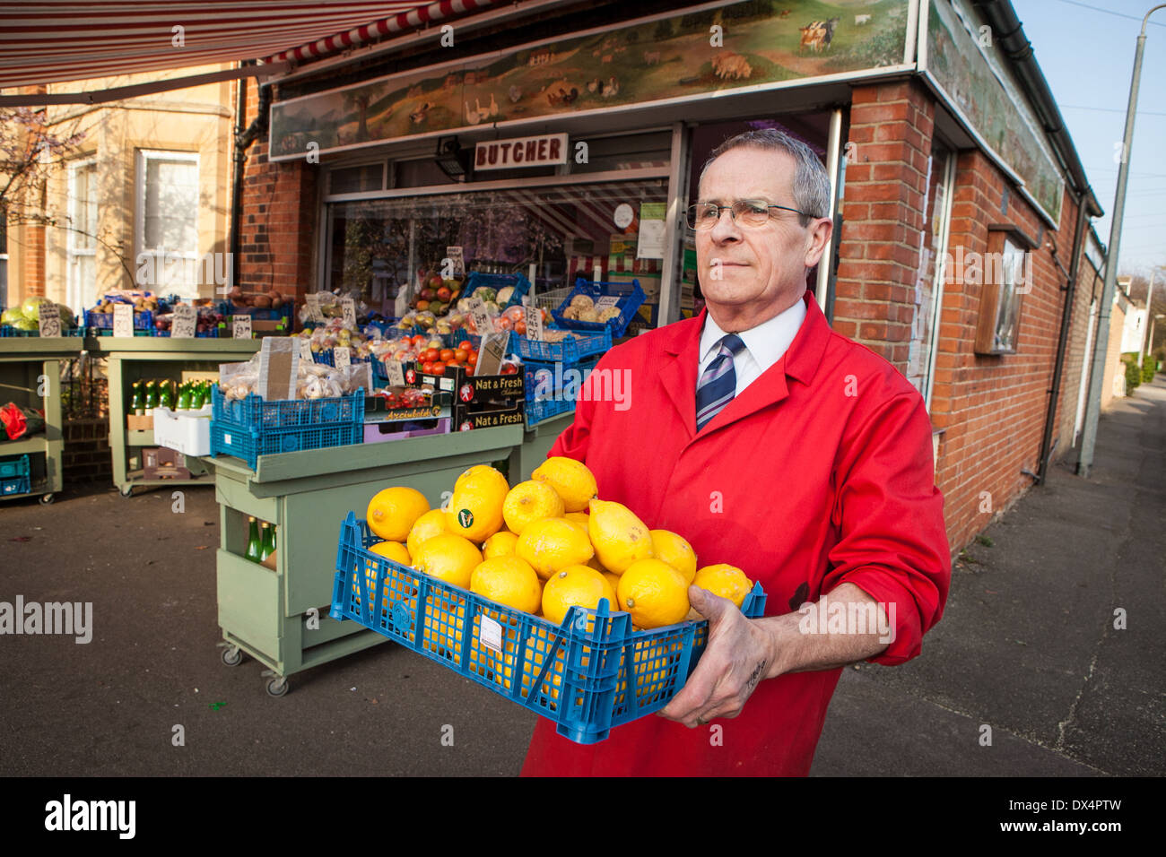 Negozio tradizionale keeper al di fuori del suo angolo shop in Cambridge, Inghilterra Foto Stock