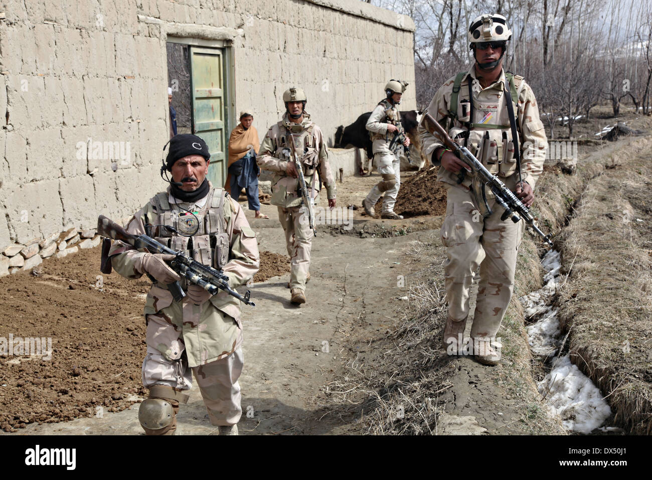 Soldati afgani con unità di attività di ricerca di Wardak un villaggio durante una ricognizione armati funzionamento Marzo 6, 2014 in Zabodaq village, provincia di Wardak, Afghanistan. Foto Stock