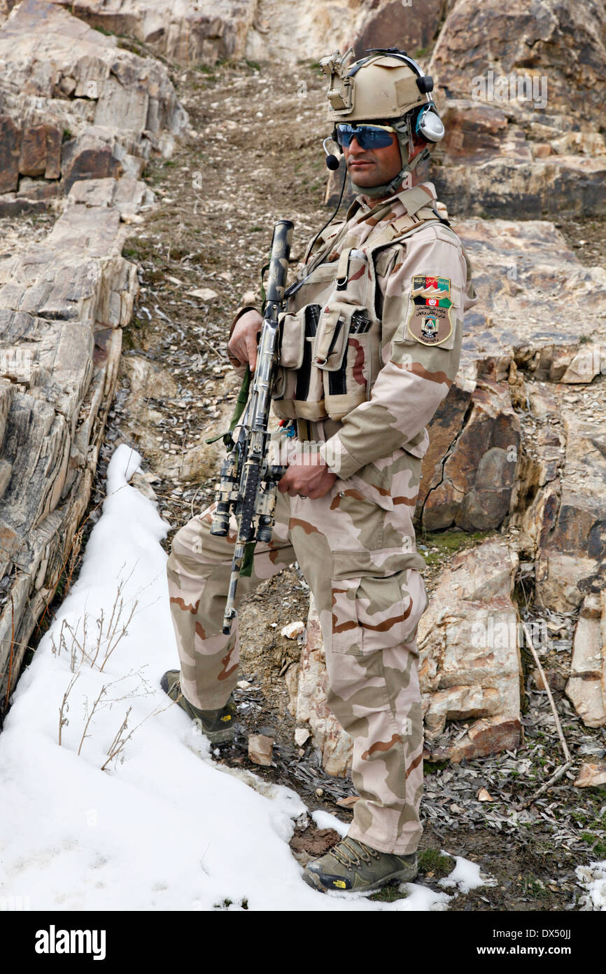 Un soldato afgano con unità di attività Wardak durante una ricognizione armati funzionamento Marzo 6, 2014 in Zabodaq village, provincia di Wardak, Afghanistan. Foto Stock