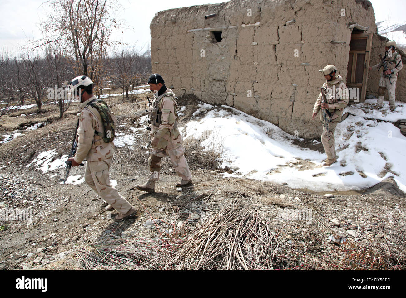 Soldati afgani con unità di attività di ricerca di Wardak un villaggio durante una ricognizione armati funzionamento Marzo 6, 2014 in Zabodaq village, provincia di Wardak, Afghanistan. Foto Stock