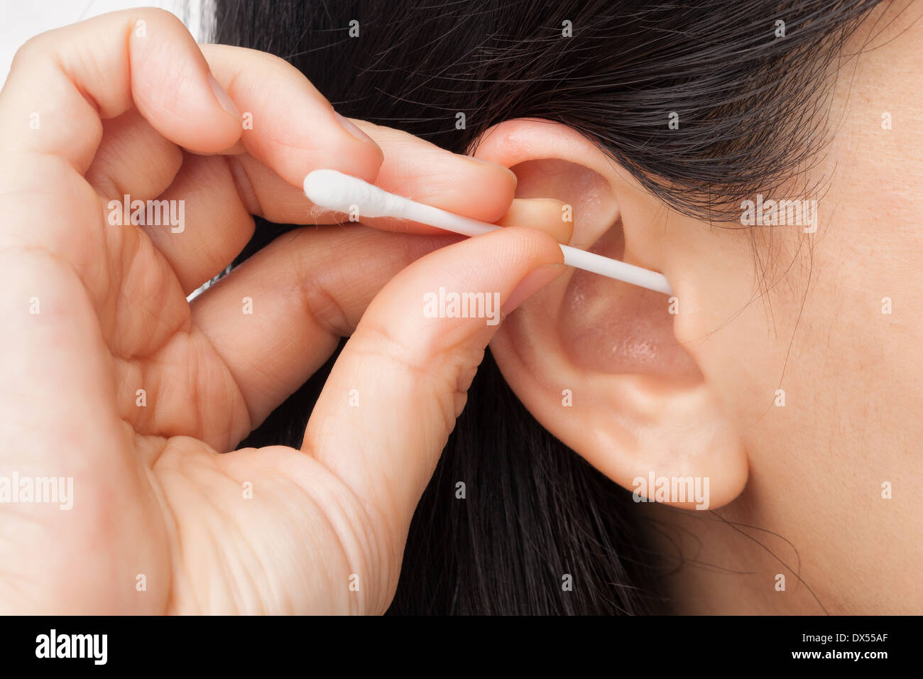 Donna orecchio di Pulizia con bastoncino di cotone Foto Stock