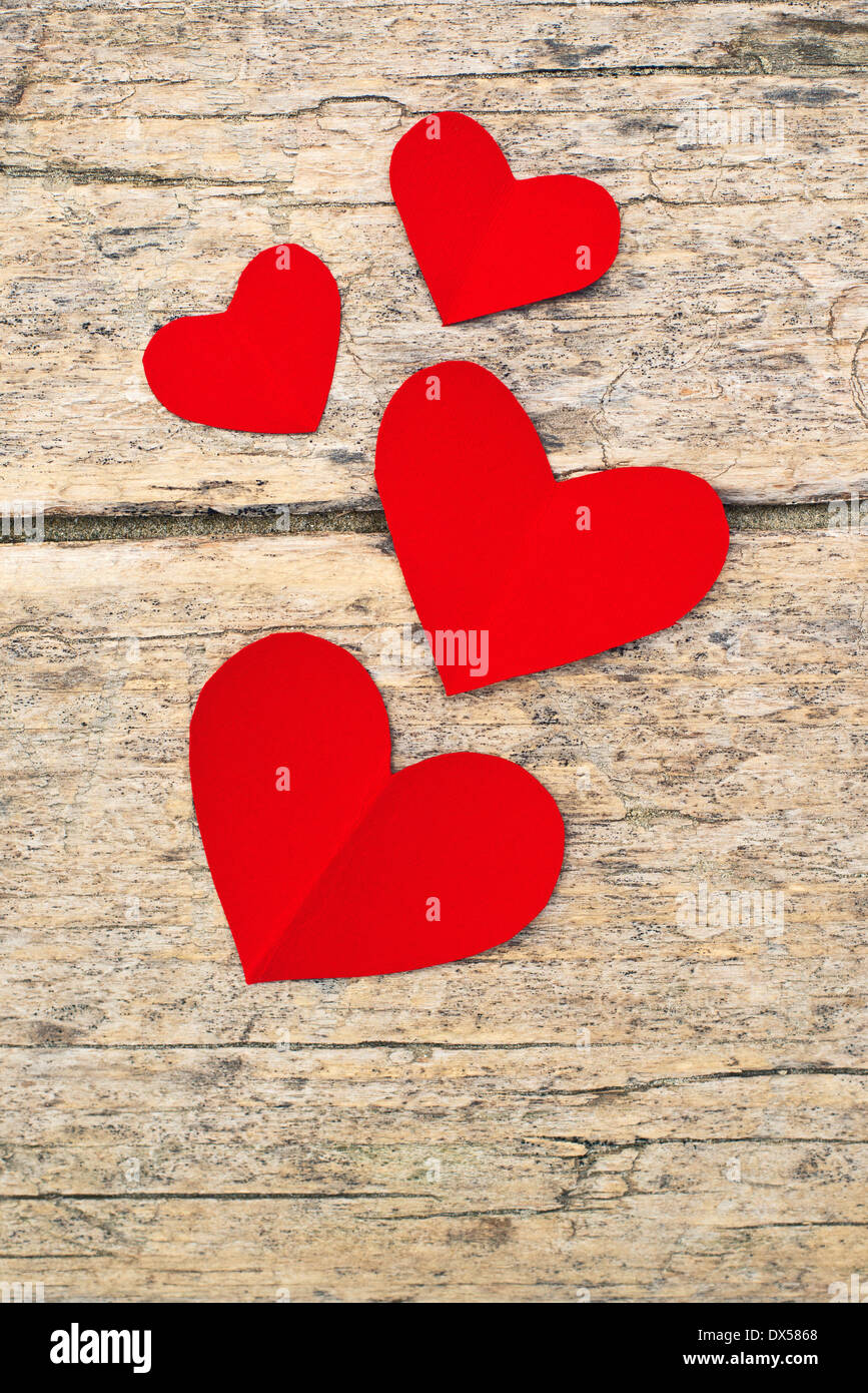 Carta rossa cuori su grunge sfondo di legno con una copia dello spazio per il tuo San Valentino messaggio Foto Stock