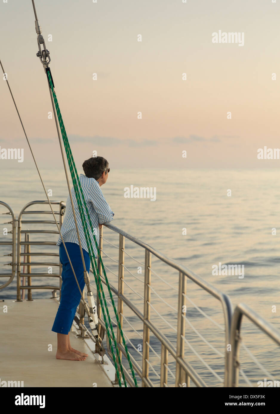 Di mezza età / senior donna su una nave da crociera con il ponte di ocean sunset Foto Stock