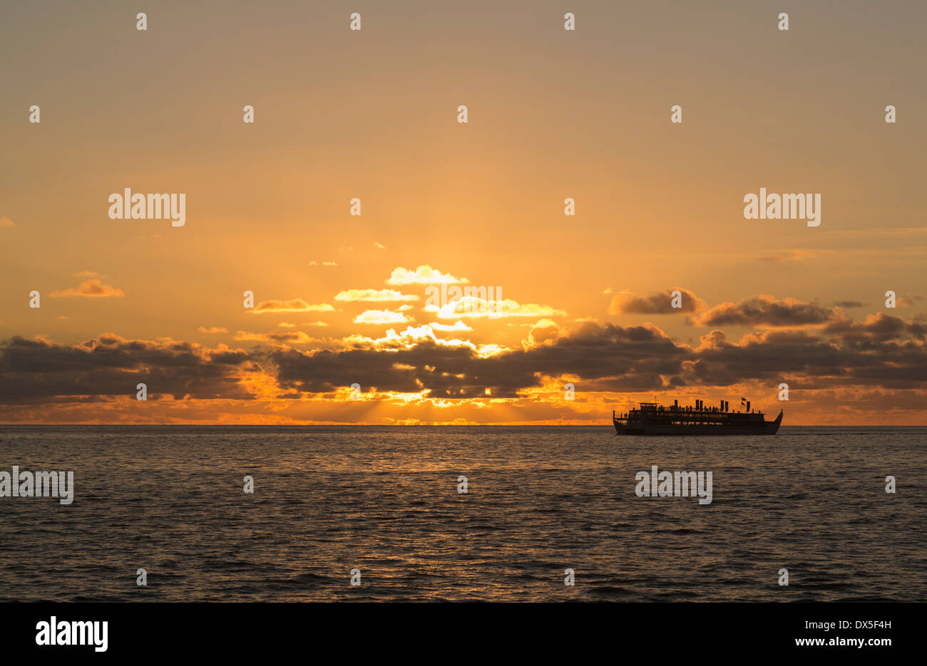 Una nave da crociera vele all'orizzonte off Oahu, Hawaii, Stati Uniti d'America al tramonto Foto Stock