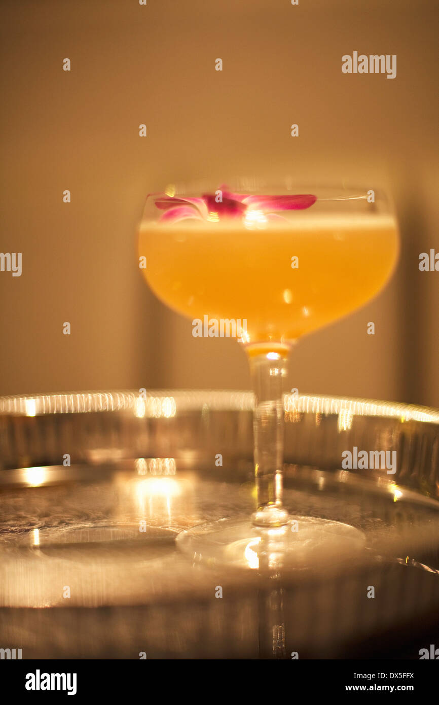 Cocktail con plumeria fiore sul vassoio d'argento, close up Foto Stock
