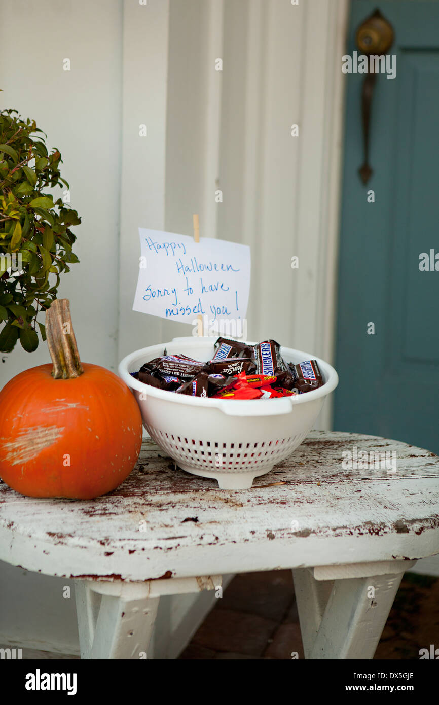 Halloween Candy con nota accanto alla zucca sul portico anteriore tabella Foto Stock