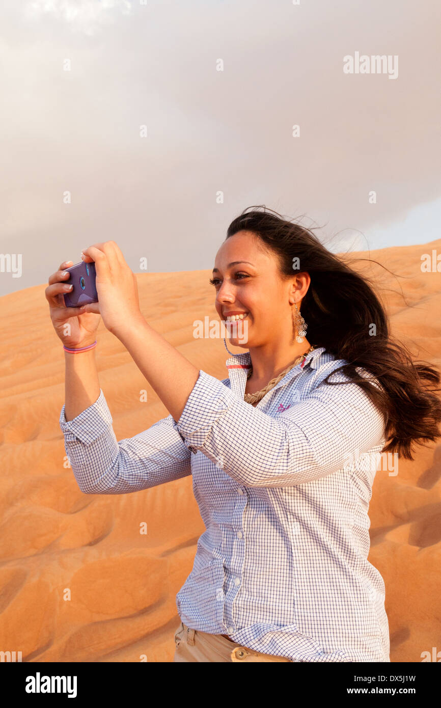 Donna prendendo un selfie foto nel deserto Arabico, in vacanza a Dubai, Emirati Arabi Uniti, Emirati Arabi Uniti Medio Oriente Foto Stock