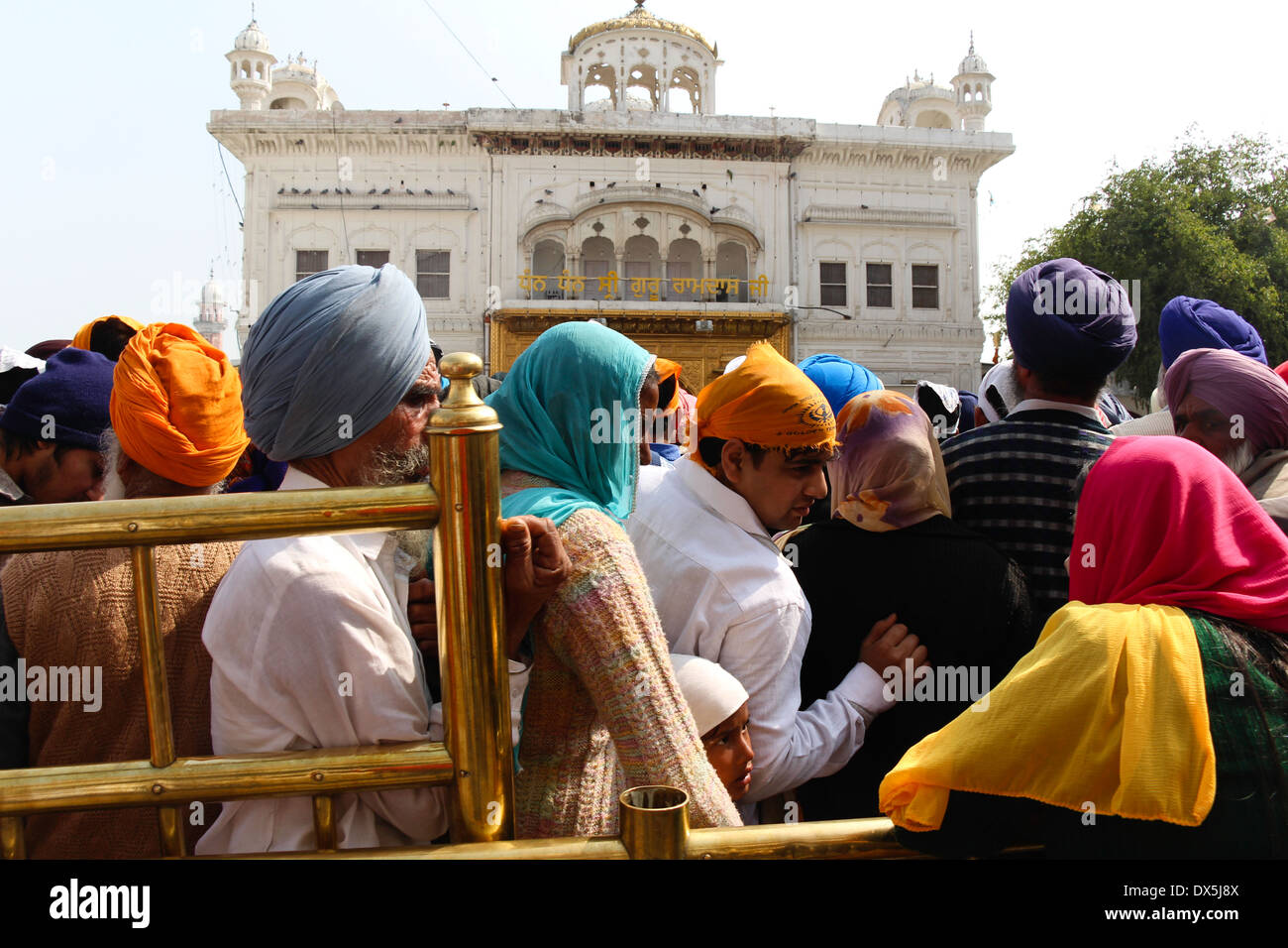 Rush di devoti all'interno del tempio d'oro di Amritsar. Per gestire la coda, vi sono sezioni separate per uomini e donne Foto Stock