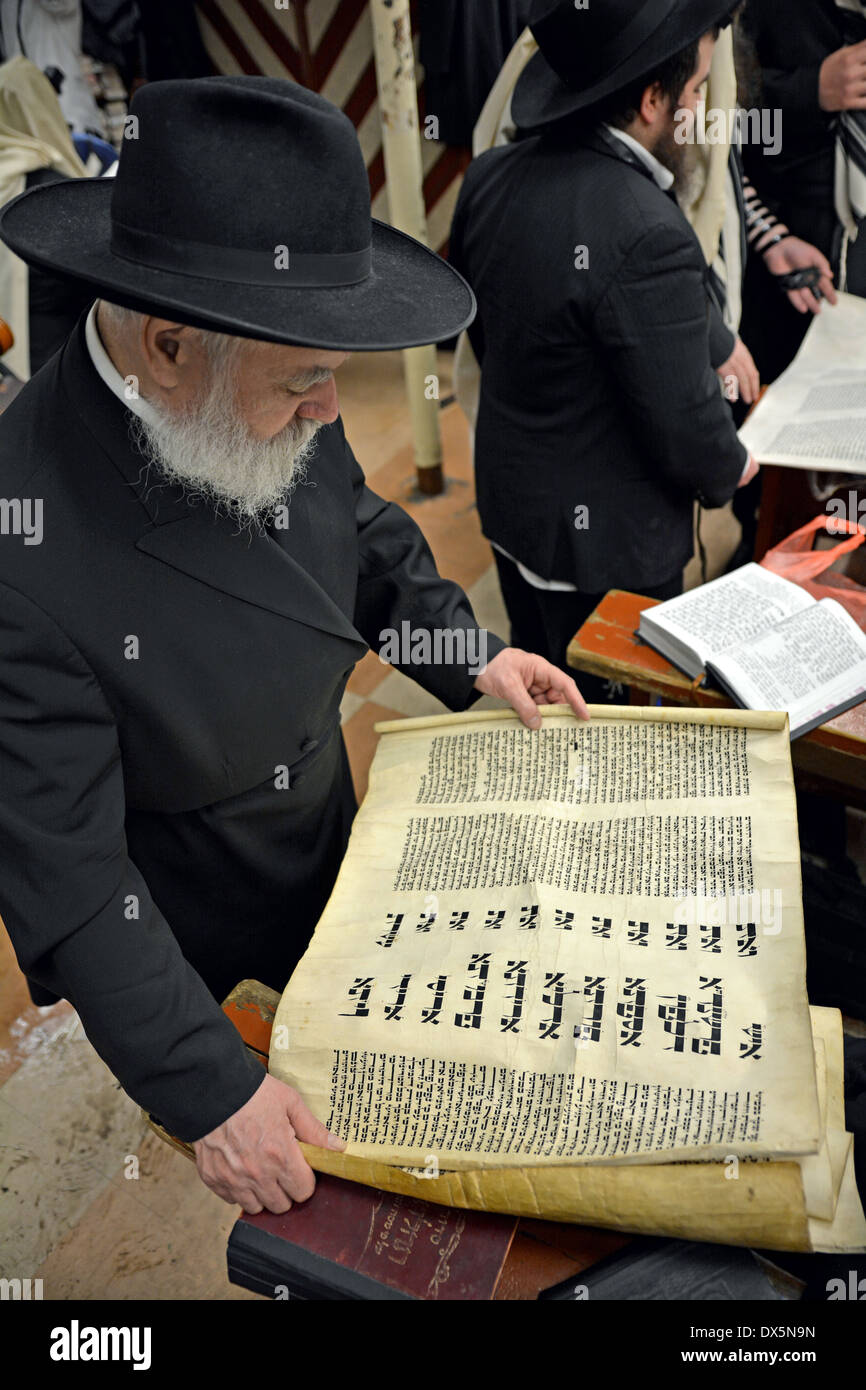 Una religiosa ebraica uomo di lettura da Megillah durante la festa di Purim servizi in Crown Heights, Brooklyn, New York Foto Stock