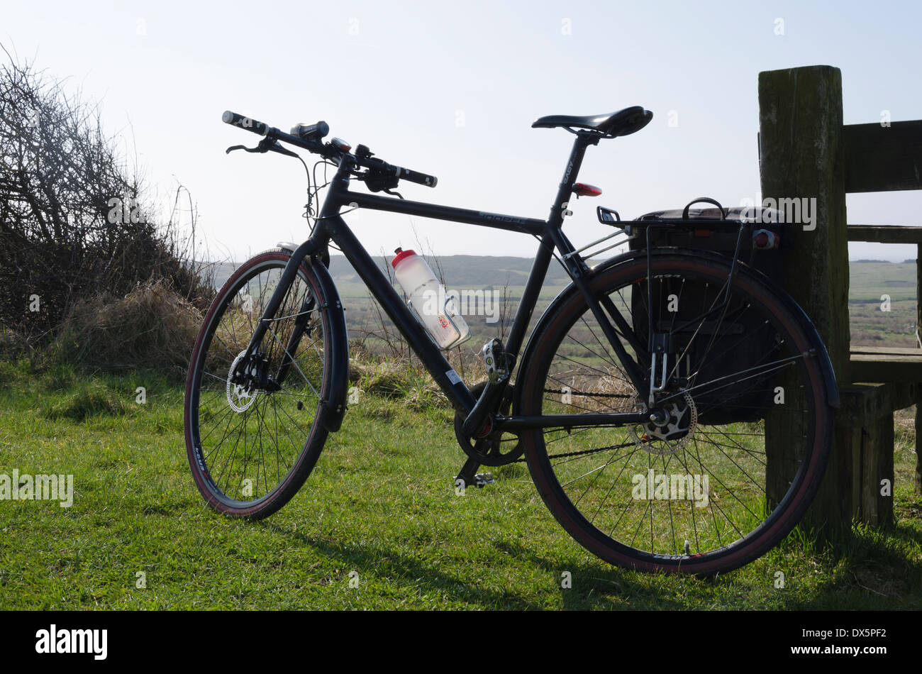 Cyclo-touring bike contro un palo di legno sulla pista ciclabile vicino Beckermet, Cumbria, Inghilterra. Foto Stock