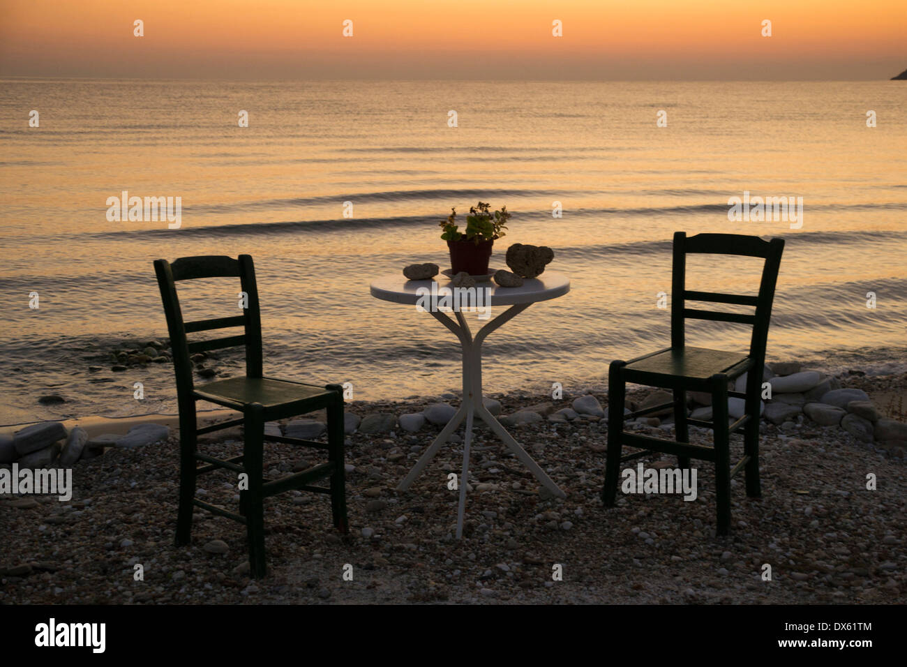 Due sedie vuote e un tavolo permanente in solitario il sole pacifica di un  mediterraneo mattina dal mare Foto stock - Alamy