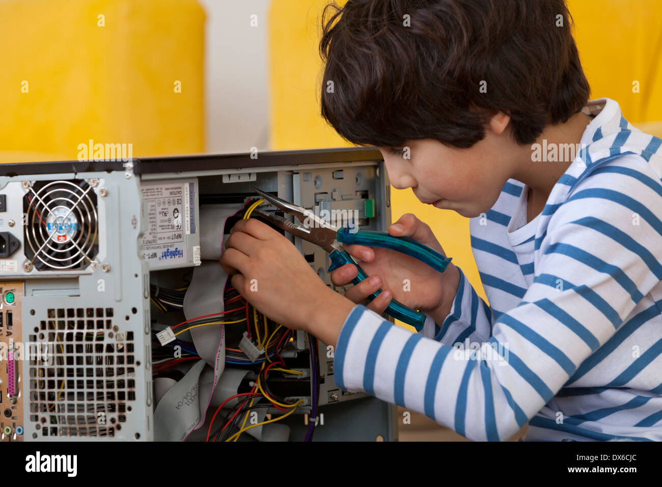 Little Boy esplorare l'interno di un computer con grande attenzione Foto Stock