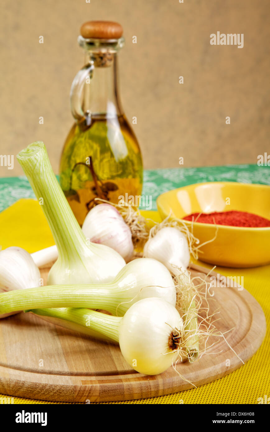 Cipolla e aglio con un olio di oliva Bottiglia su un tavolo da cucina Foto Stock