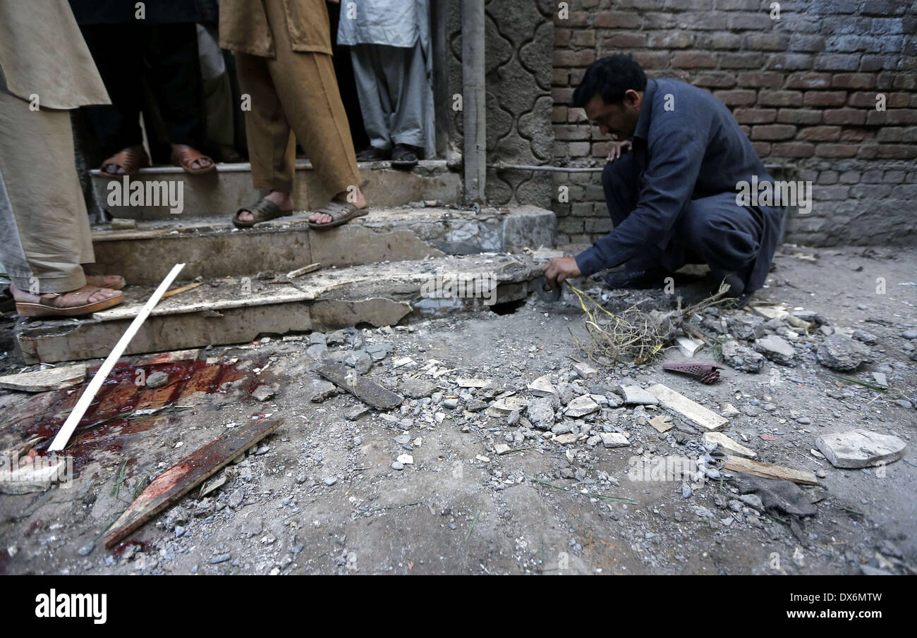 Peshawar. Xix Mar, 2014. Un poliziotto in plain-vestiti ispeziona un sito blast nel nord-ovest del Pakistan Peshawar il 19 marzo 2014. Almeno cinque persone sono state ferite come blast scosso Peshawar inizio mercoledì mattina, i media locali hanno riferito. Credito: Umar Qayyum/Xinhua/Alamy Live News Foto Stock