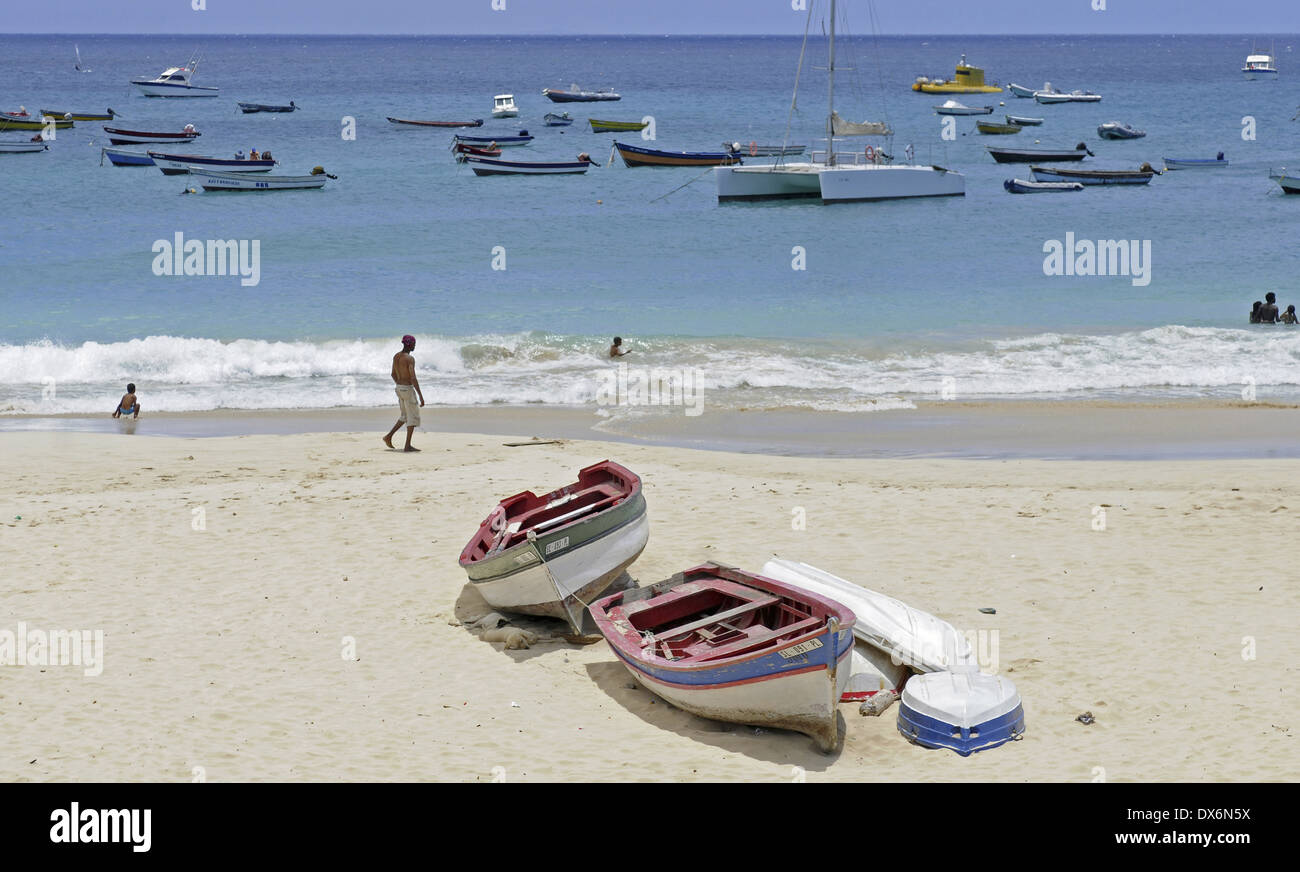 Barche in legno sulla sabbia e le barche ormeggiate in mare sulla spiaggia di Santa Maria. Persone in acqua e sulla riva. Foto Stock