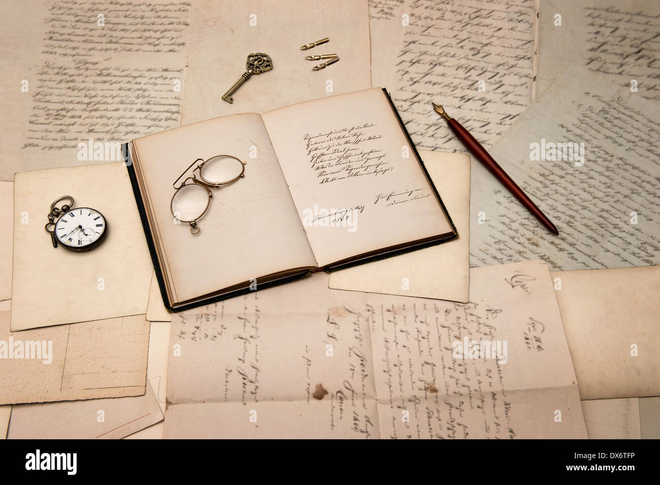 Accessori vintage e libro aperto sopra il vecchio lettere e cartoline. sfondo nostalgico Foto Stock