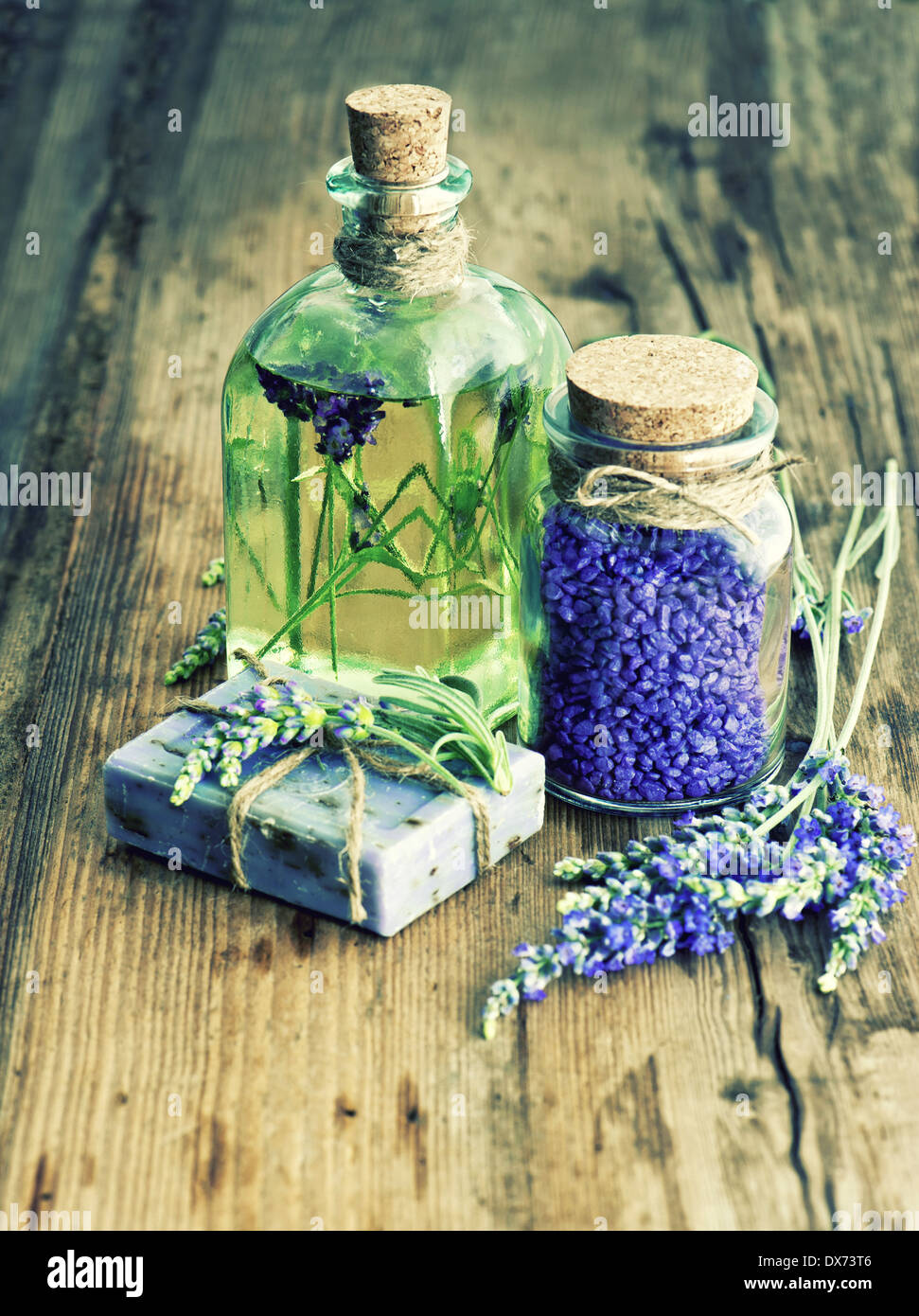 Essenziale di olio di lavanda, sapone a base di erbe e di sale da bagno con fiori freschi su sfondo di legno. stile retrò immagine. messa a fuoco selettiva Foto Stock