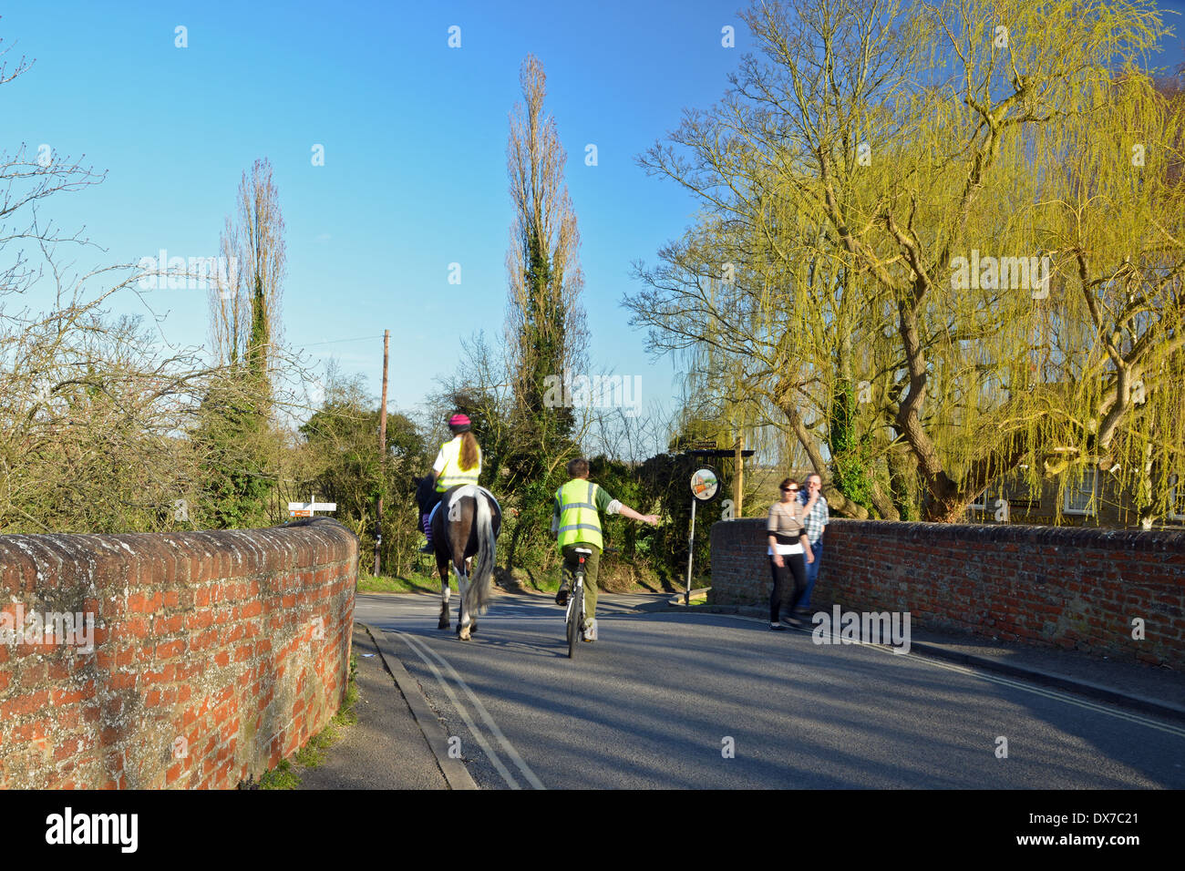 Cavallo e cavaliere con ciclista su strada di campagna Foto Stock