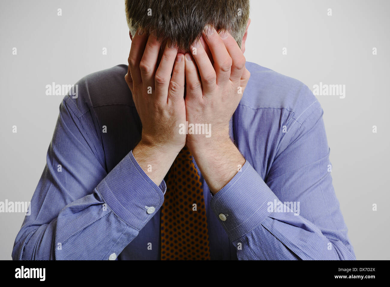 Imprenditore con la testa tra le mani. Foto Stock