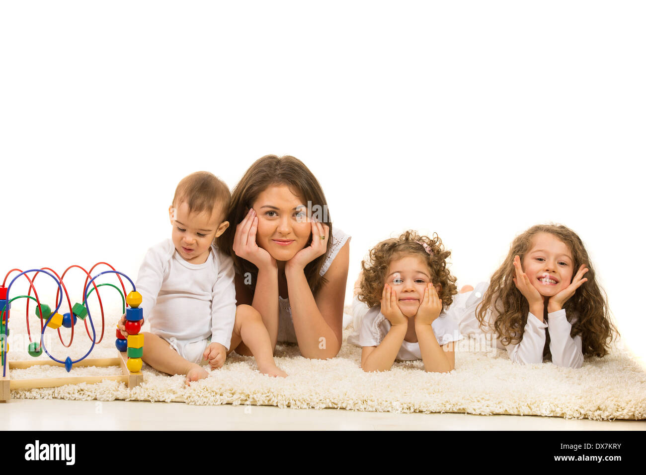 Bella famiglia posa in una fila sul tappeto di pelliccia home contro uno sfondo bianco Foto Stock