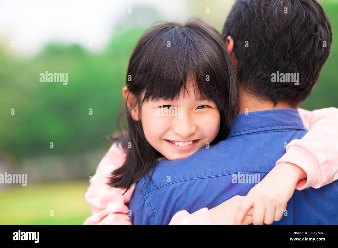 Bellissima bambina abbracciando abbracciando il suo padre nel parco Foto Stock