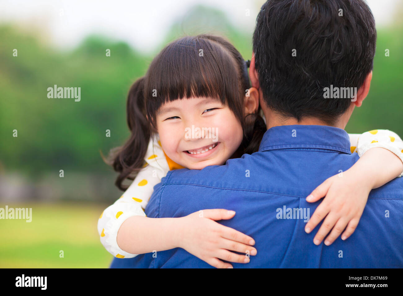 Felice bambina abbracciando abbracciando il suo padre nel parco Foto Stock