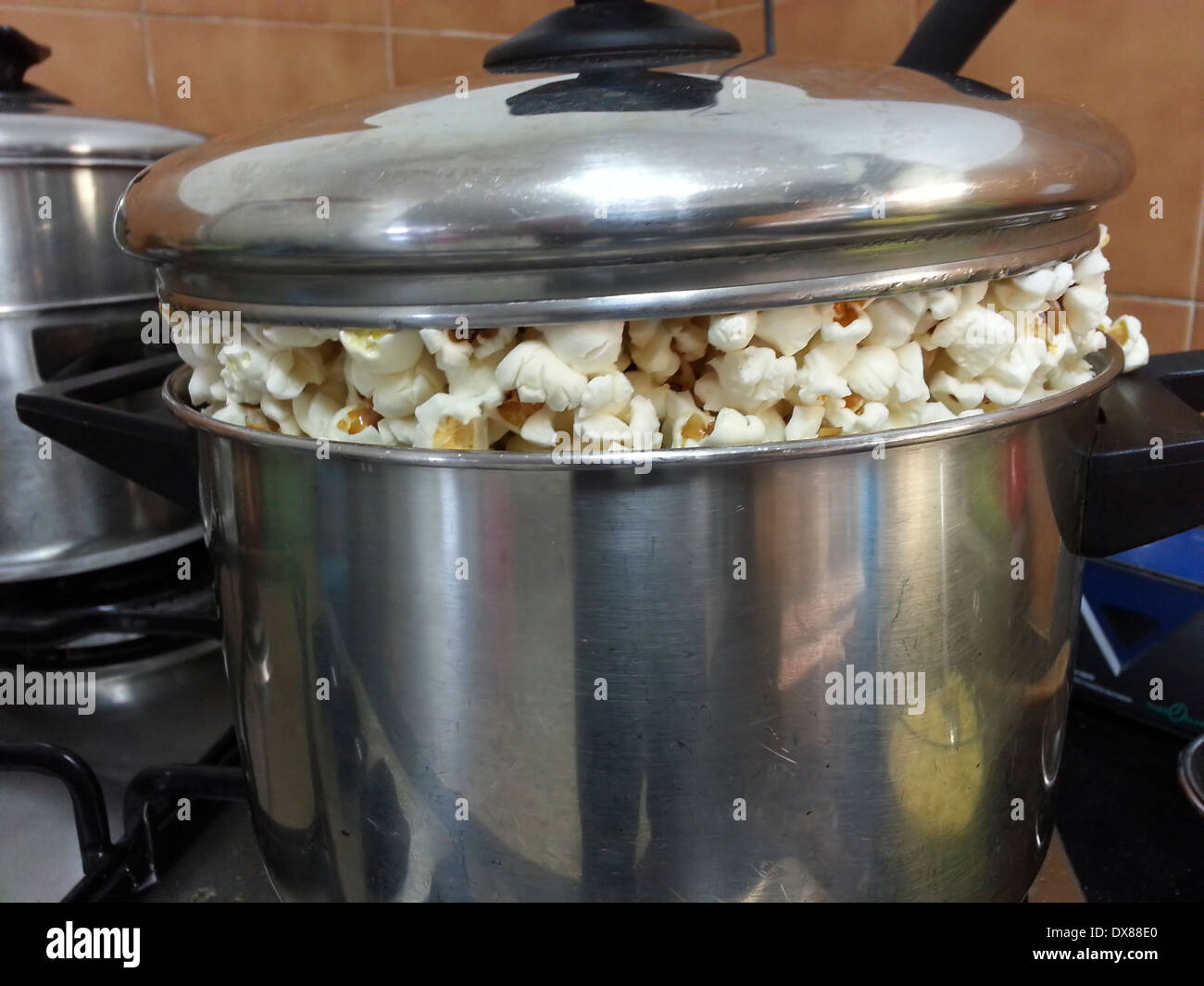 Una pentola di pop corn su un fornello a gas Foto stock - Alamy