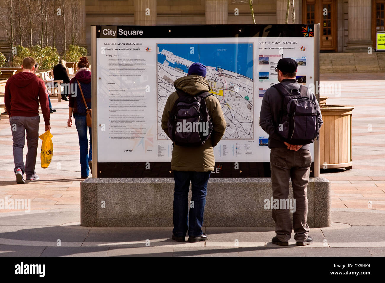 Due turisti guardando le informazioni turistiche di bordo per le direzioni Nel centro di Dundee, Regno Unito Foto Stock