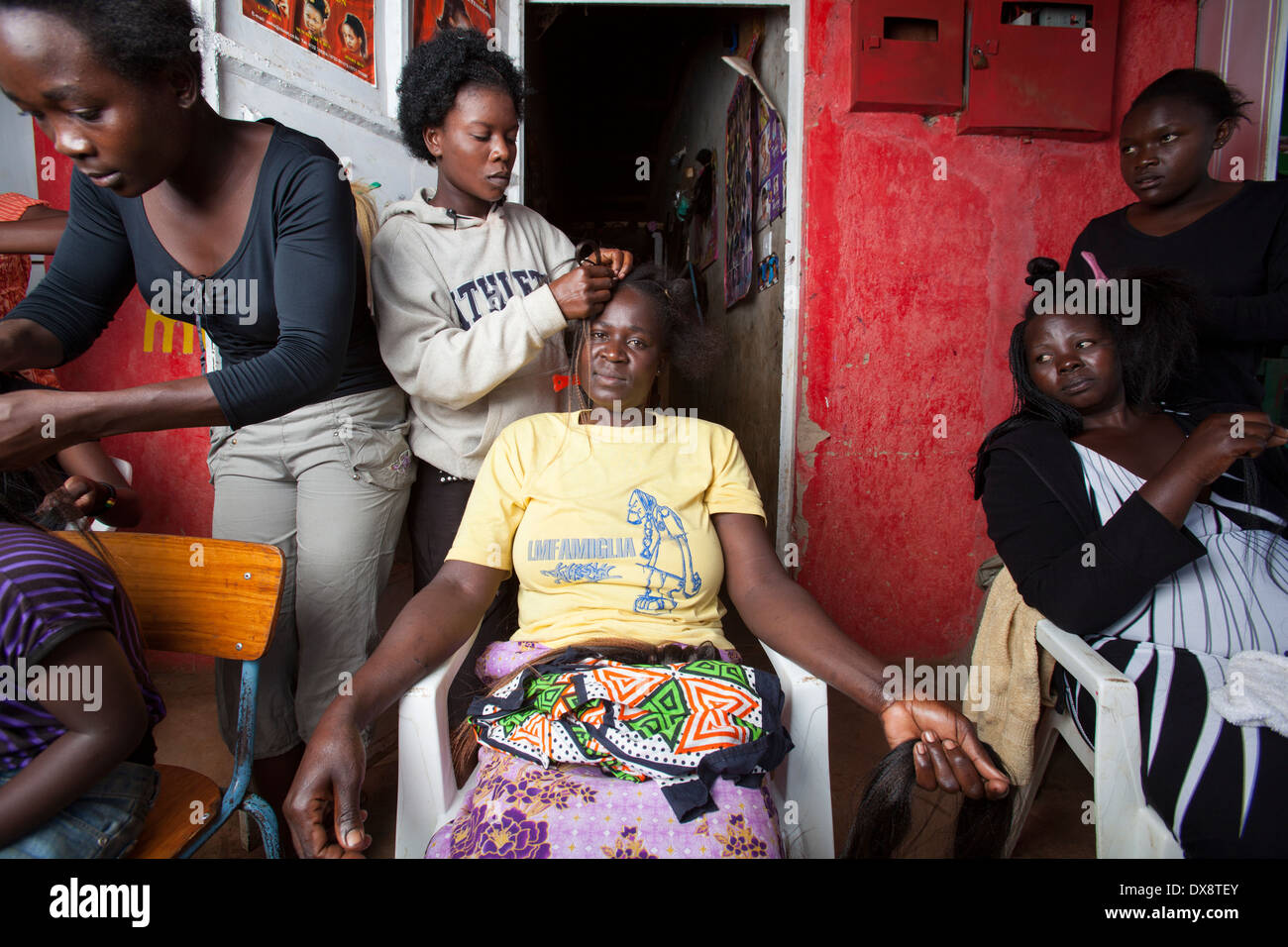 Donna con capelli intrecciati a un parrucchiere, Kisumu regione, Kenya Foto Stock