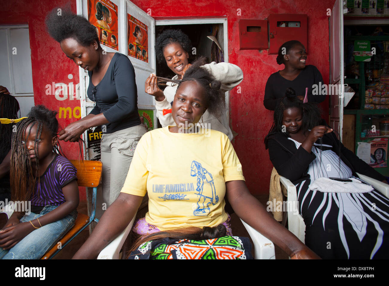 Donna con capelli intrecciati a un parrucchiere, Kisumu regione, Kenya Foto Stock