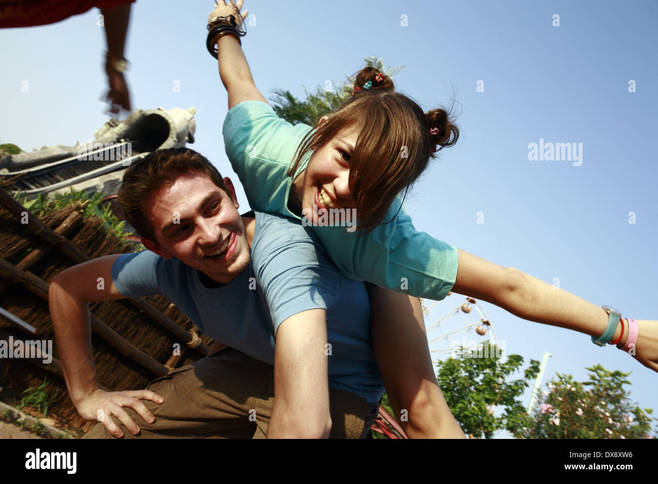 Giovane adolescente giocando su piggy back nel parco di divertimenti Foto Stock