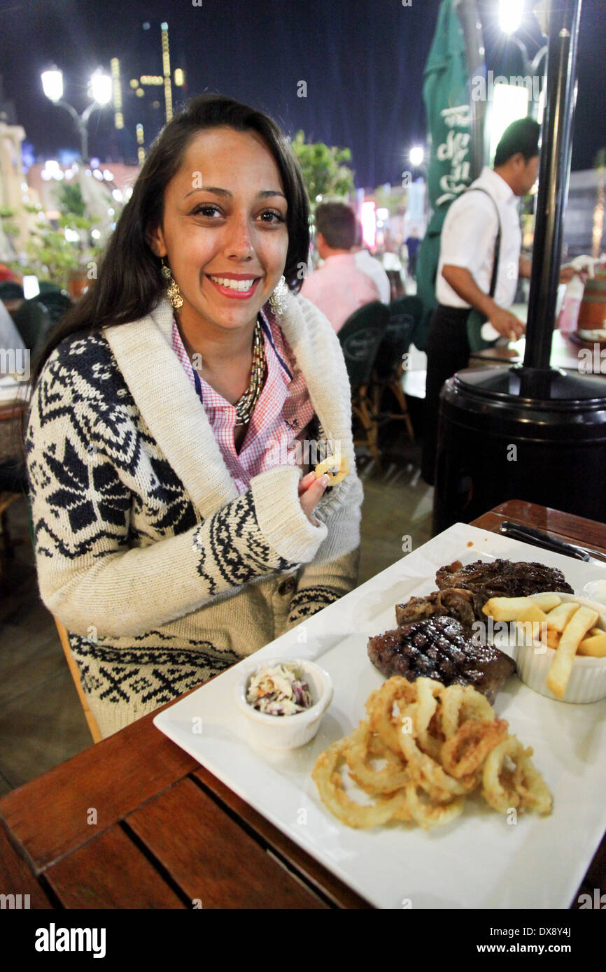 Giovane donna in vacanza a mangiare un pasto a base di bistecca e patatine in un ristorante, Dubai, Emirati Arabi Uniti, Emirati Arabi Uniti, Medio Oriente Foto Stock