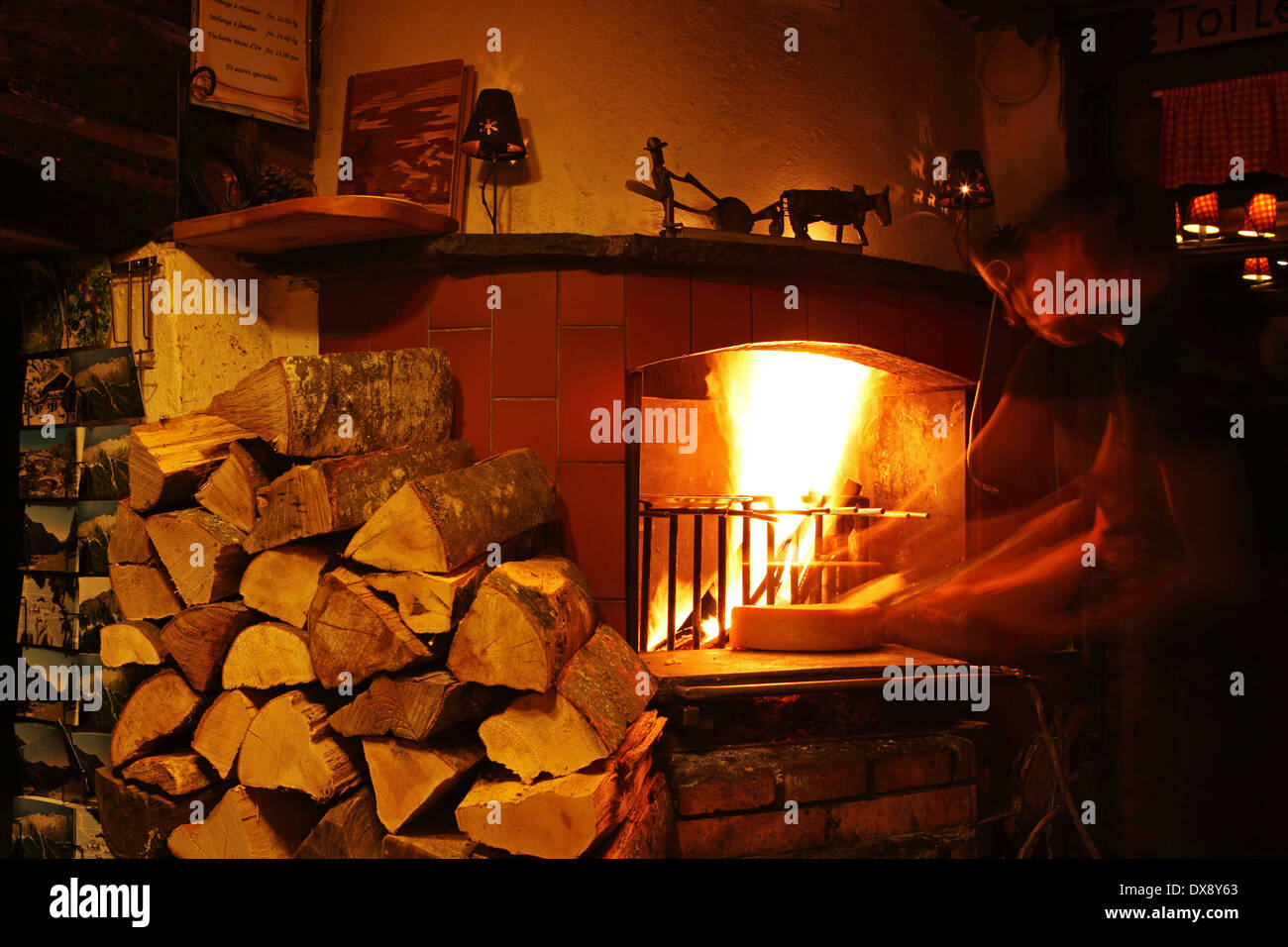 La raclette viene preparato con un fuoco aperto in Solalex vicino a Villars, Svizzera. Foto Stock
