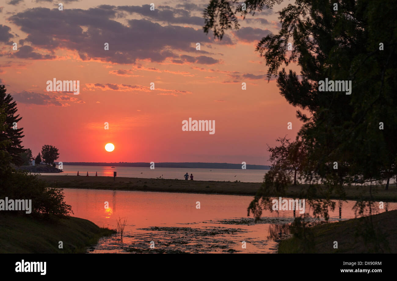 Estate tramonto al parco. Il sole tramonta oltre il fiume Ottawa e viene riflessa in stagni artificiali che è il parco del punto focale Foto Stock