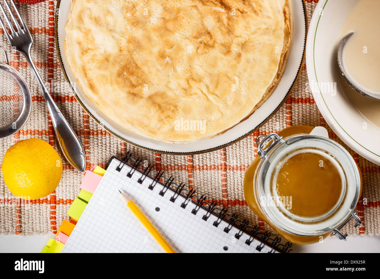 Pancake con il libro di ricette sul tavolo da cucina Foto Stock