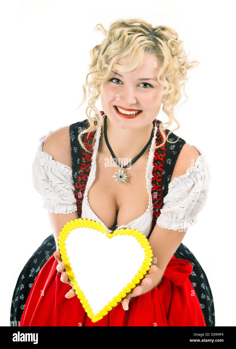 Giovane donna nel tipico abito bavarese dirndl con cuore telaio sagomato per il testo Foto Stock