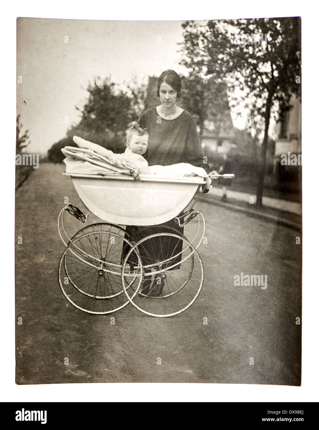 Vecchie foto di famiglia. Madre con bambino in buggy vintage. nostalgico foto con grana di pellicola dal 1923 Foto Stock