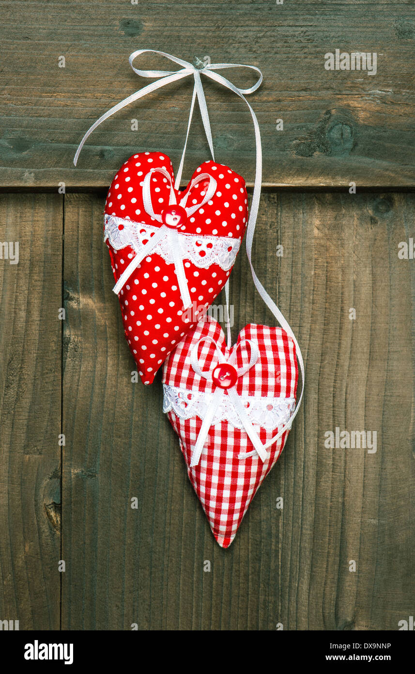 Cuori rossi appesi sopra lo sfondo di legno. Romantico San Valentino di concetto. in stile vintage tonica foto Foto Stock