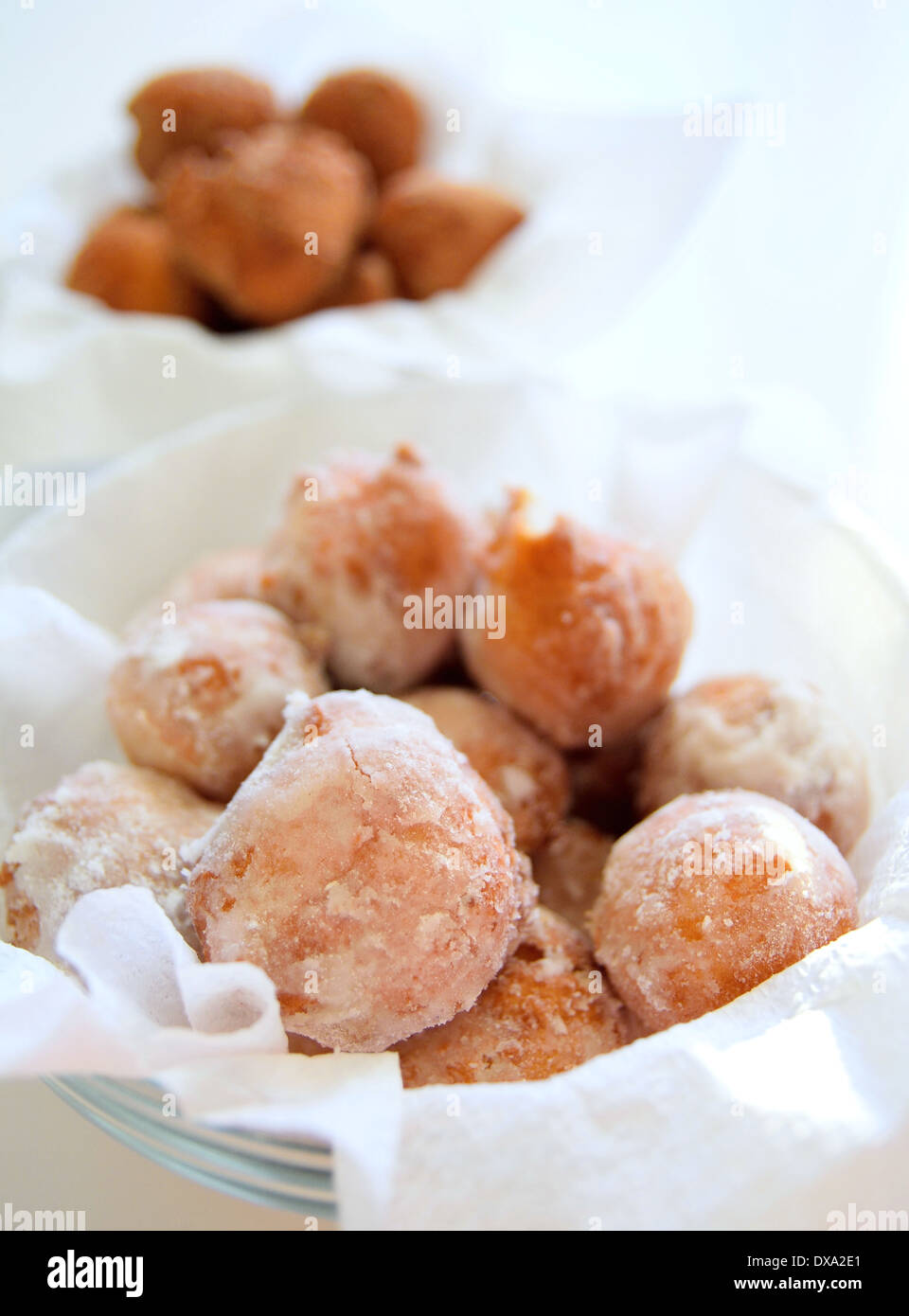 Ciambelle fritte in una ciotola di polvere da zucchero. Foto Stock