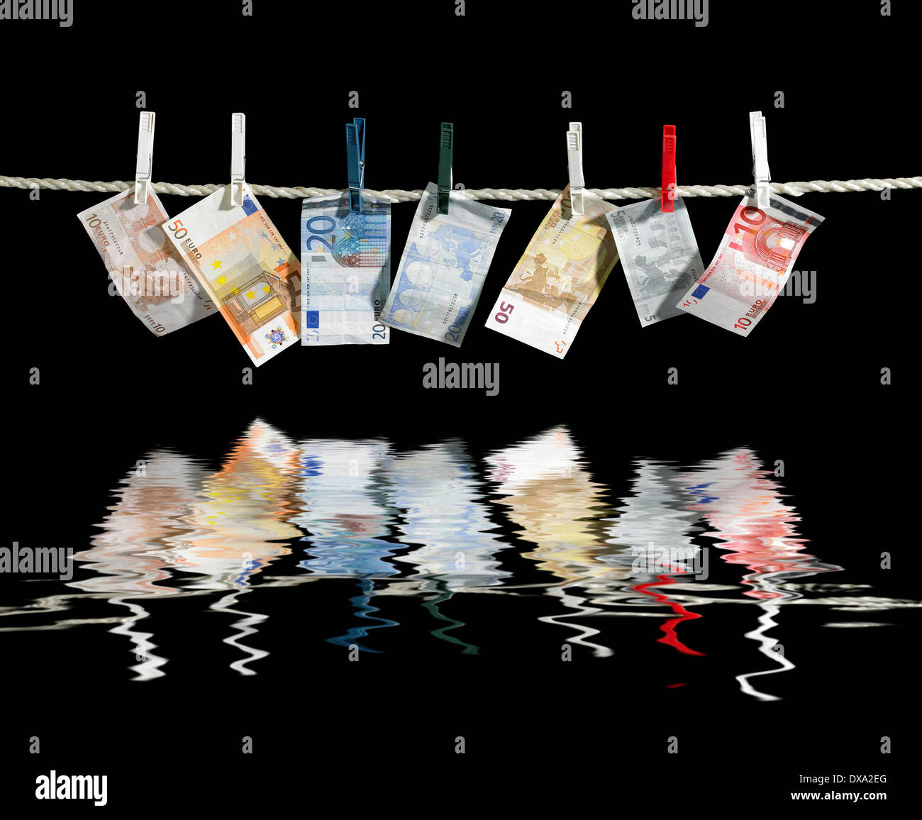 Stendibiancheria con alcune banconote in euro fissata con perni di indumenti riflettenti sulla superficie di acqua nella parte posteriore in nero Foto Stock